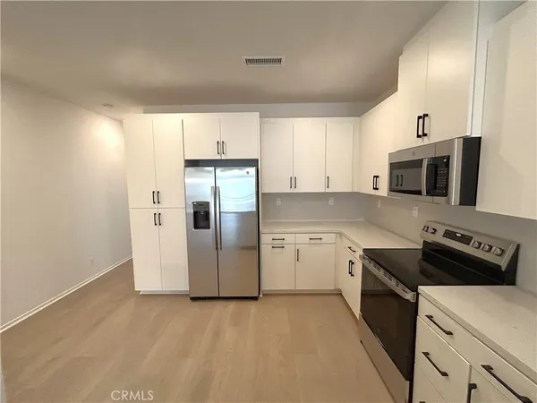 a view of a kitchen with white cabinets