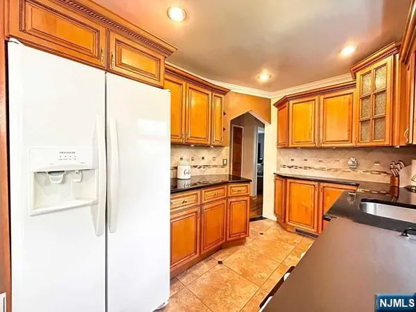 a kitchen with stainless steel appliances granite countertop sink refrigerator and cabinets