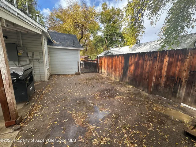 a view of a house with a yard and wooden fence