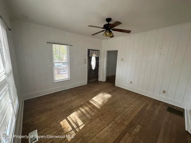a view of empty room with window and ceiling fan