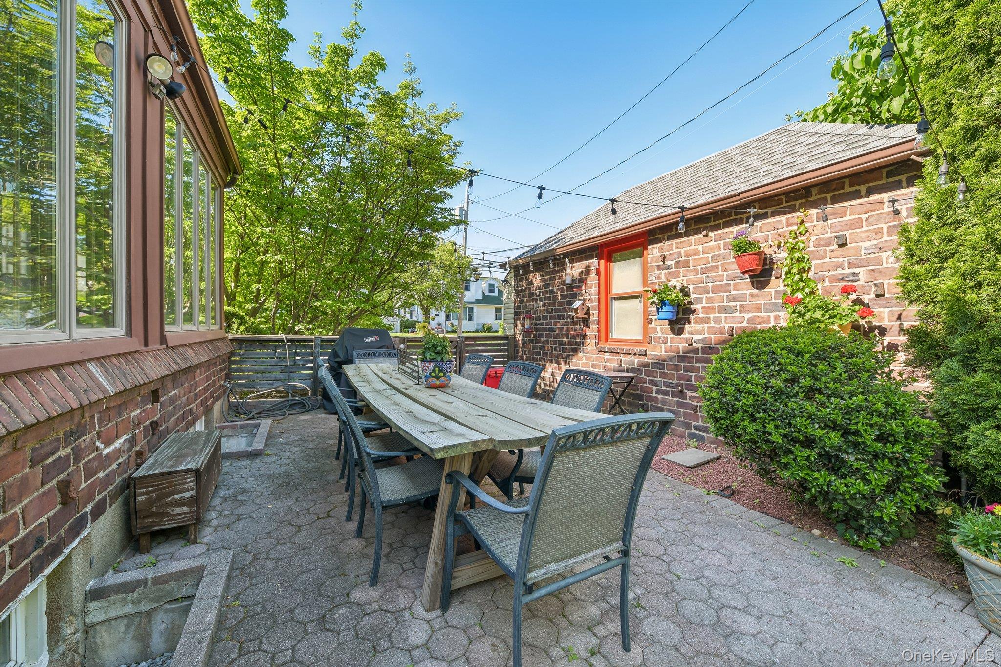 60 Croyden Road Mineola, NY 11501 - Photo 31 of 33 Paved patio featuring a brick exterior, extensive fenestration, and mature plantings