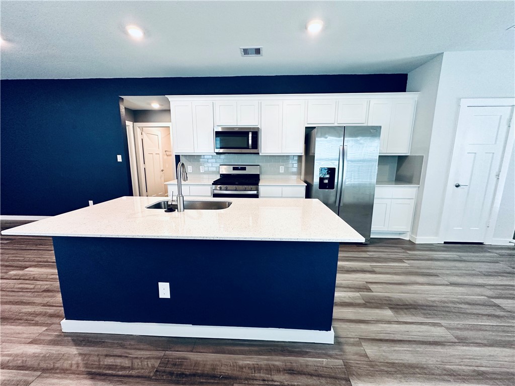 1118 Amistad Loop College Station, TX 77845 - Photo 6 of 26 a kitchen with kitchen island sink and refrigerator