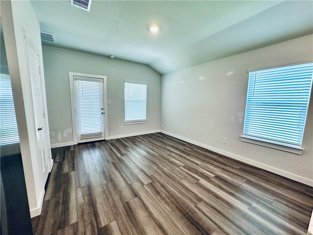 1118 Amistad Loop College Station, TX 77845 - Photo 9 of 26 an empty room with wooden floor and windows