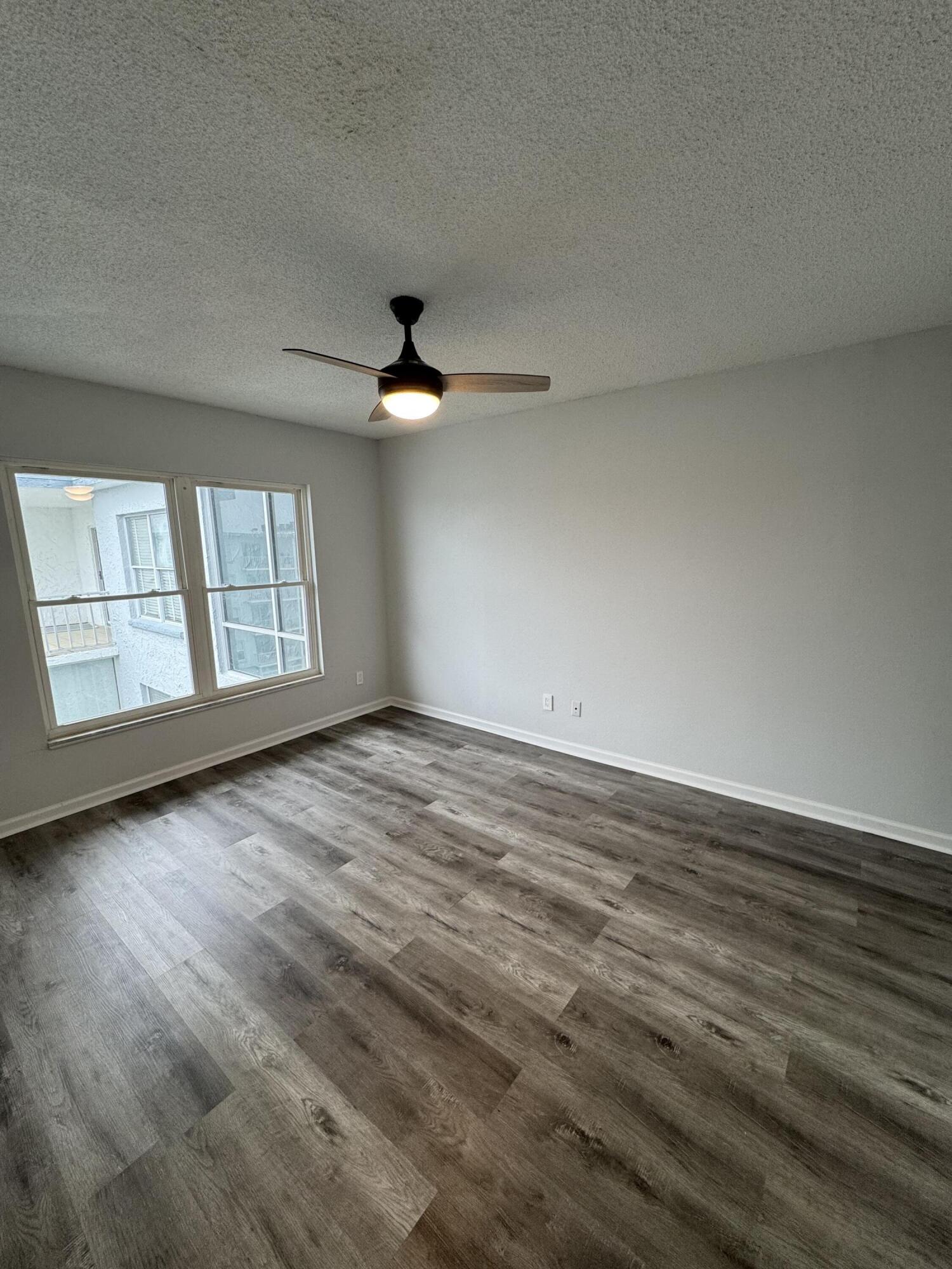 3857 Indian Trail, Unit 507 Destin, FL 32541 - Photo 19 of 33 an empty room with wooden floor fan and windows