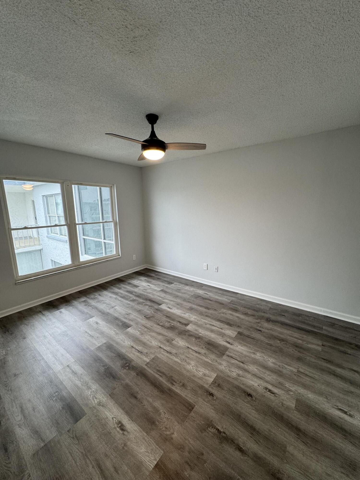 3857 Indian Trail, Unit 507 Destin, FL 32541 - Photo 20 of 33 an empty room with wooden floor fan and windows