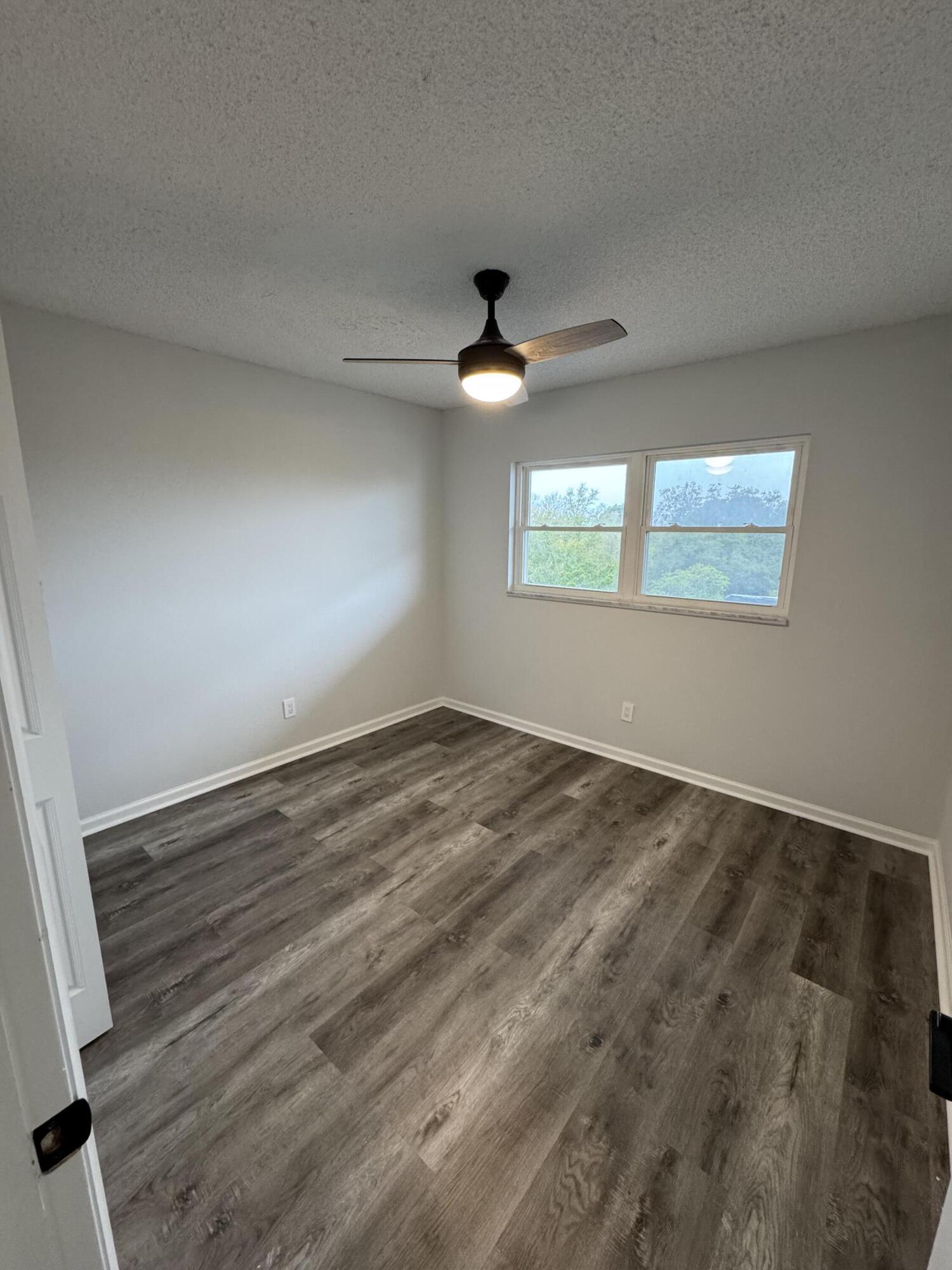 3857 Indian Trail, Unit 507 Destin, FL 32541 - Photo 6 of 33 an empty room with wooden floor and windows