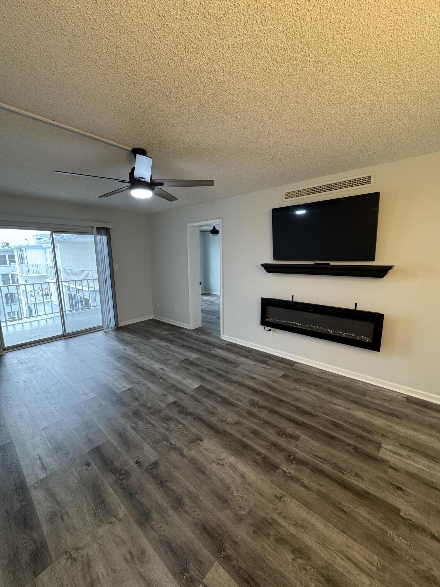 3857 Indian Trail, Unit 507 Destin, FL 32541 - Photo 8 of 33 a view of a livingroom with a flat screen tv wooden floor and a ceiling fan