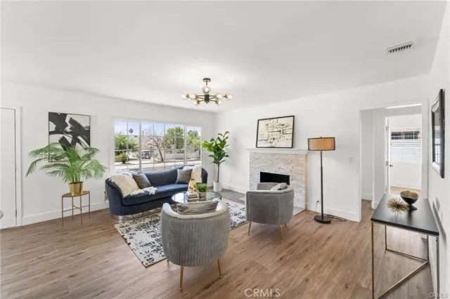 a living room with furniture a fireplace and a potted plant