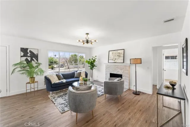 a living room with furniture a fireplace and a potted plant