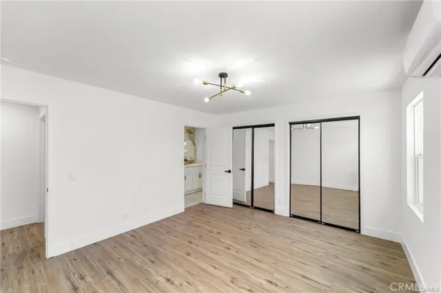 an empty room with wooden floor and a ceiling fan