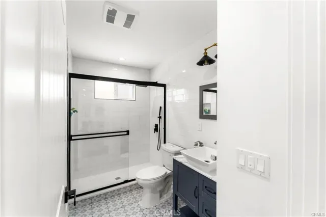 a bathroom with a granite countertop sink toilet and shower