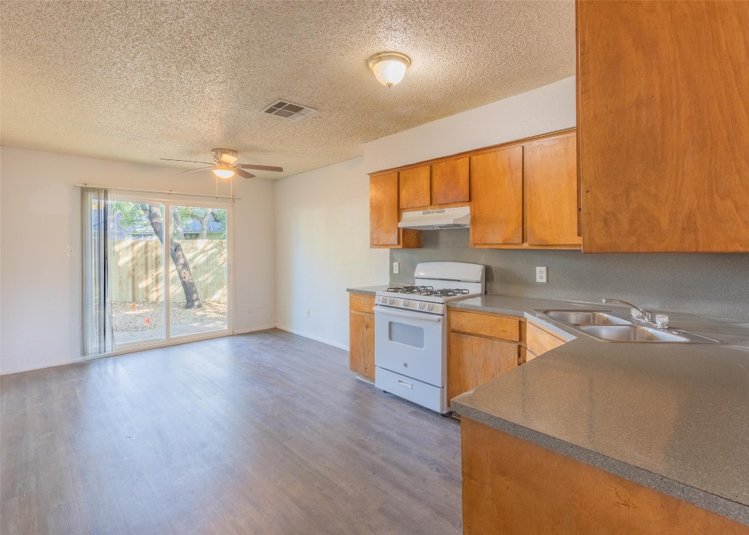 4600 Rocking Chair Road, Unit B Austin, TX 78744 - Photo 2 of 7 a kitchen with a sink wooden floor and window