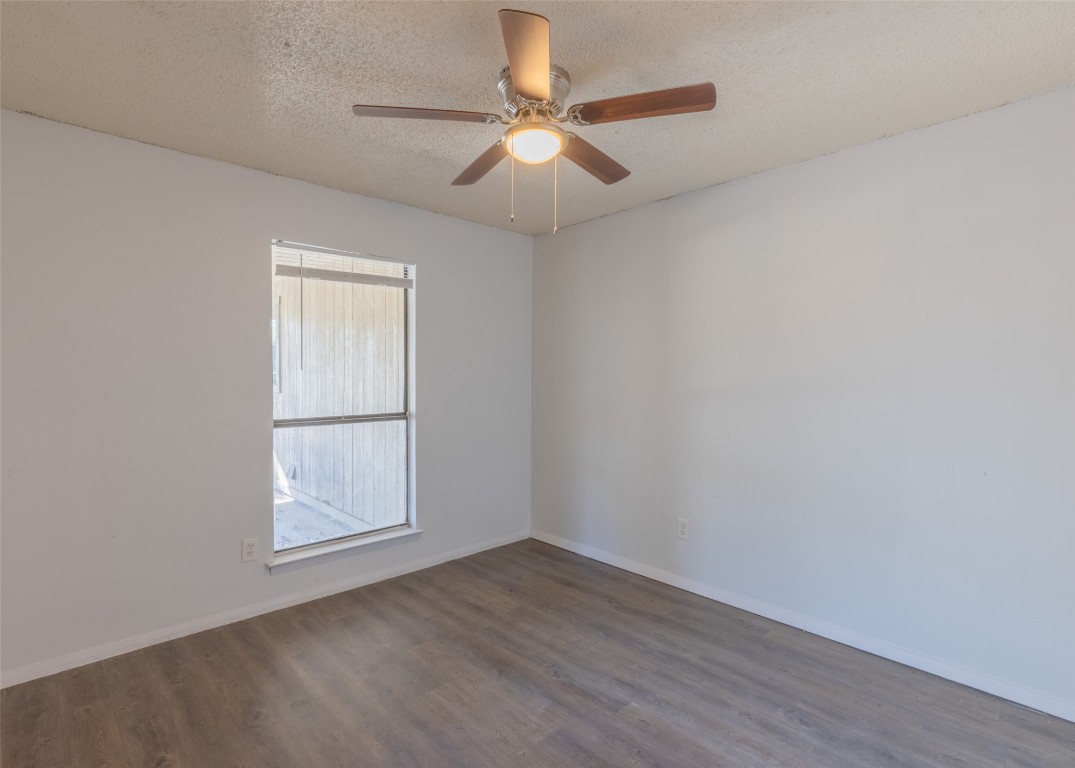 4600 Rocking Chair Road, Unit B Austin, TX 78744 - Photo 4 of 7 an empty room with wooden floor chandelier fan and windows