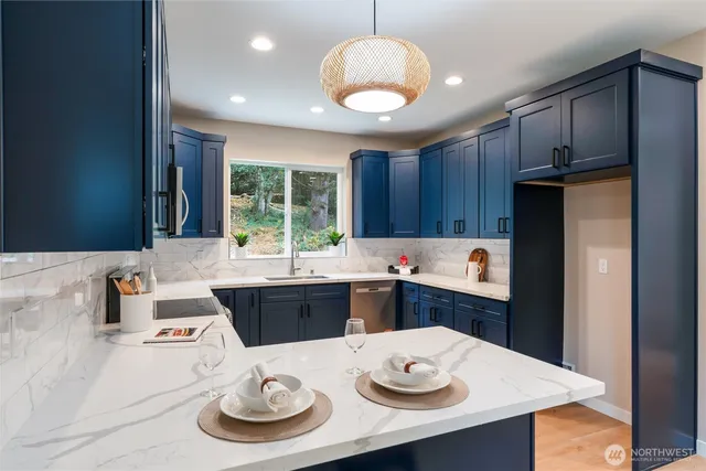 a kitchen with stainless steel appliances kitchen island granite countertop a dining table and chairs