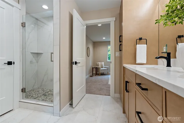 a bathroom with a granite countertop sink mirror and shower