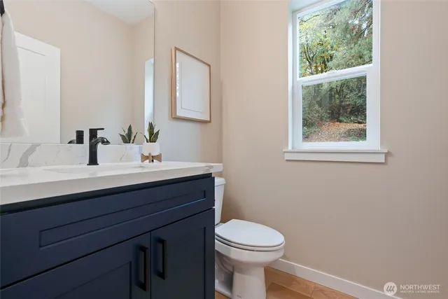 a bathroom with a sink vanity mirror and toilet