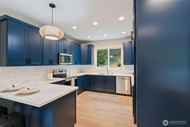 a kitchen with stainless steel appliances granite countertop wooden cabinets a stove a sink and a refrigerator