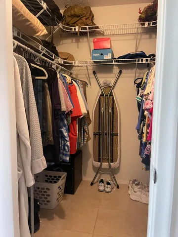 a view of walk in closet with clothes and shoes
