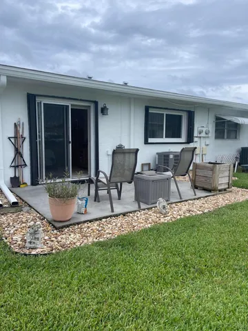 a view of a house with backyard sitting area and porch