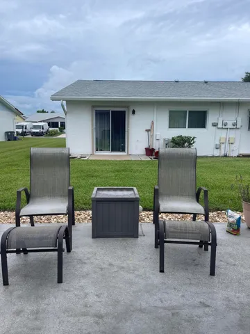 a view of a house with a yard and sitting area
