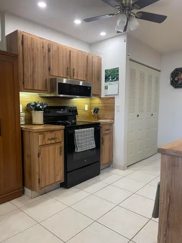 a kitchen with wooden cabinets and a stove top oven
