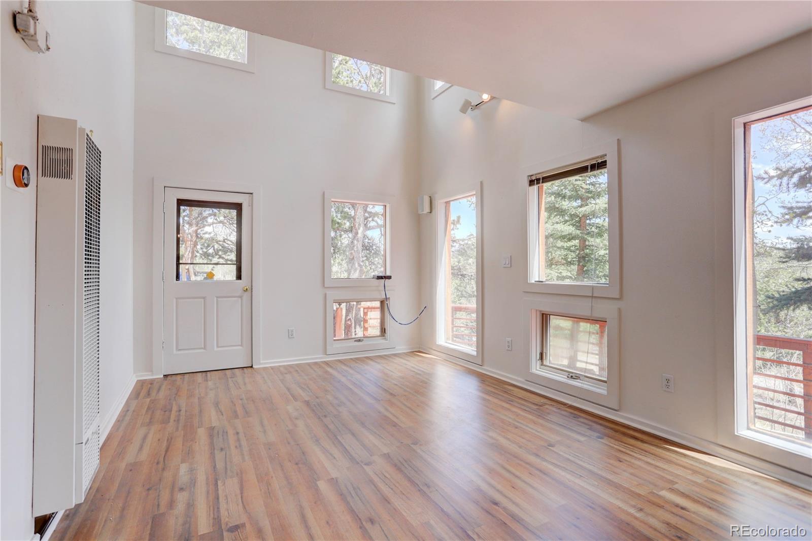 400 Alpine Way Idaho Springs, CO 80452 - Photo 17 of 40 a view of an empty room with wooden floor and a window