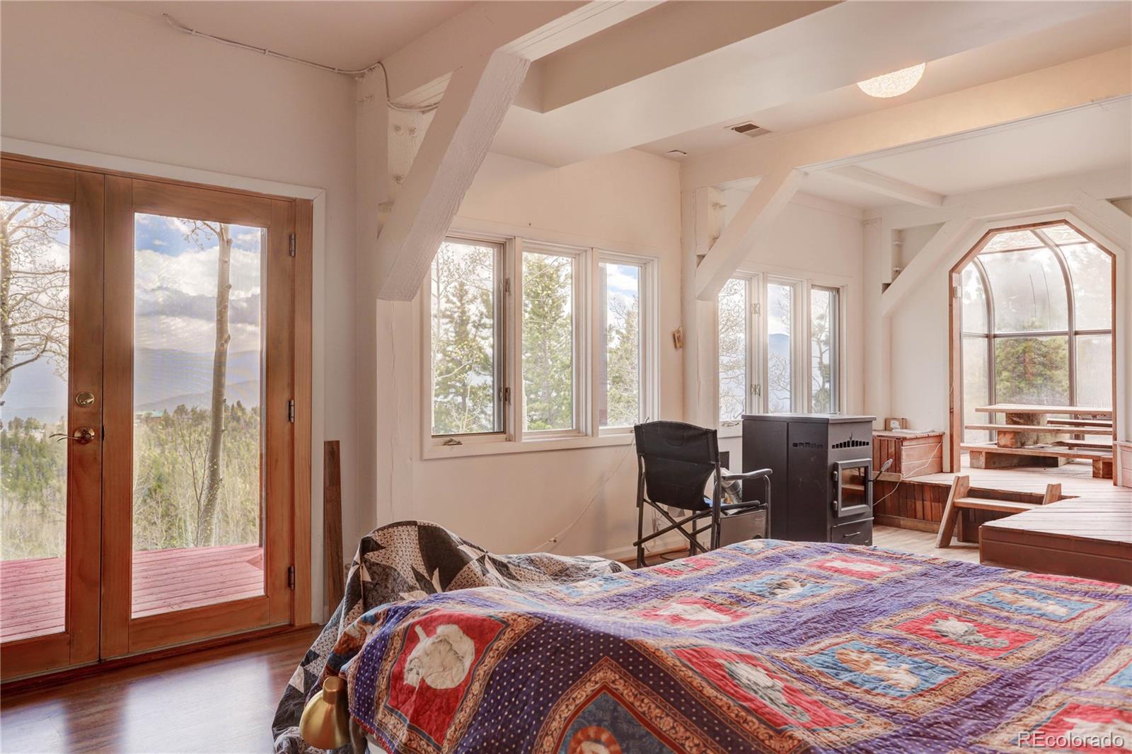 400 Alpine Way Idaho Springs, CO 80452 - Photo 29 of 40 a bedroom with a bed and large windows