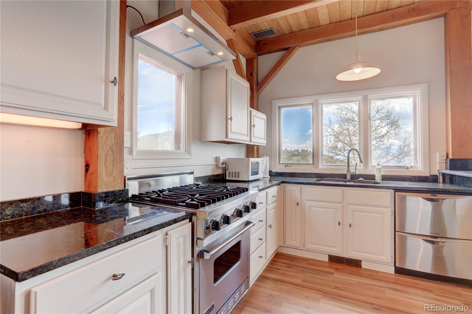 400 Alpine Way Idaho Springs, CO 80452 - Photo 8 of 40 a kitchen with granite countertop a sink a stove and cabinets