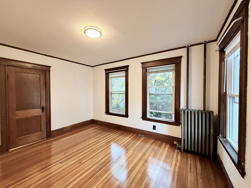 20 Clark Street, Unit 1 Framingham, MA 01702 - Photo 11 of 17 a view of an empty room with wooden floor and a window