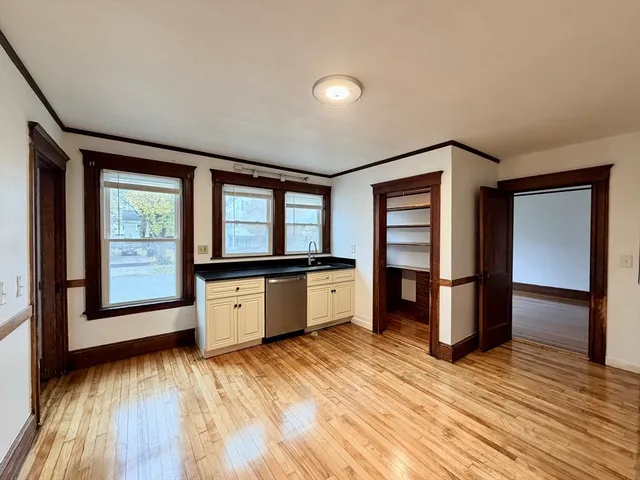 a large kitchen with a wooden floor and large window