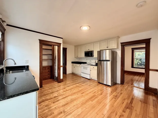 a kitchen with granite countertop a refrigerator and a stove top oven
