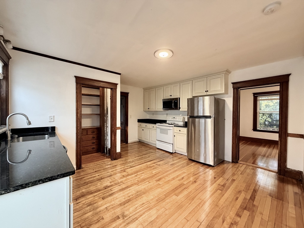 20 Clark Street, Unit 1 Framingham, MA 01702 - Photo 14 of 17 a kitchen with granite countertop a refrigerator and a stove top oven
