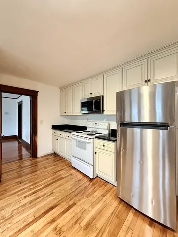a kitchen with granite countertop a refrigerator stove and microwave