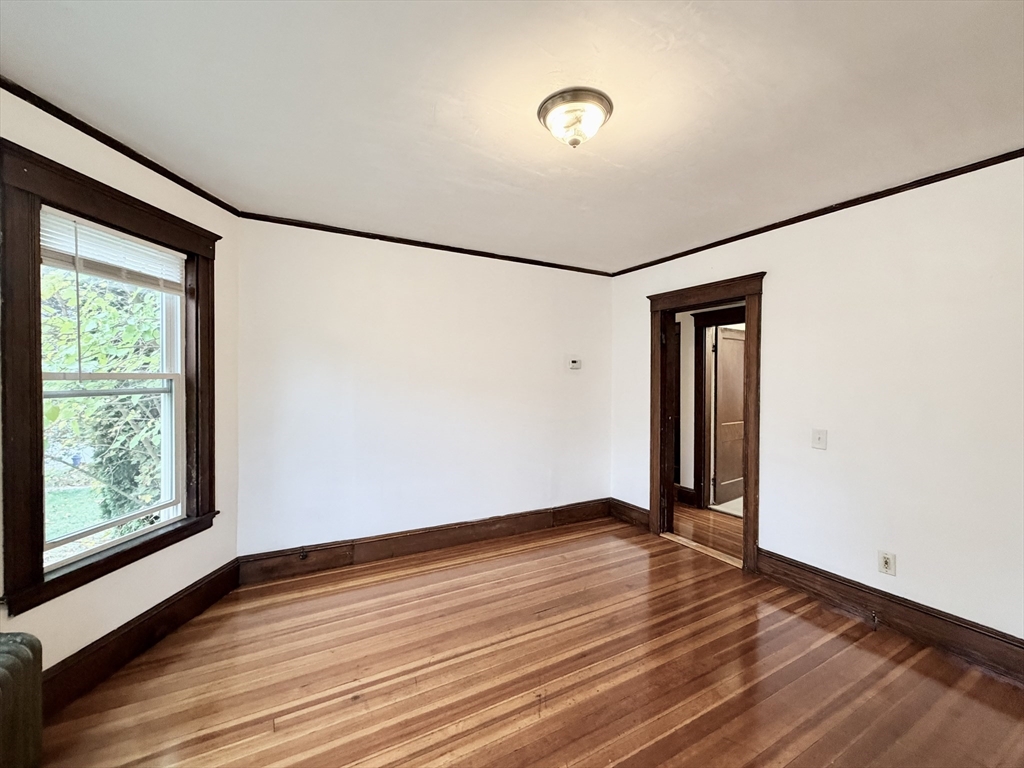 20 Clark Street, Unit 1 Framingham, MA 01702 - Photo 4 of 17 a view of an empty room with wooden floor and a window
