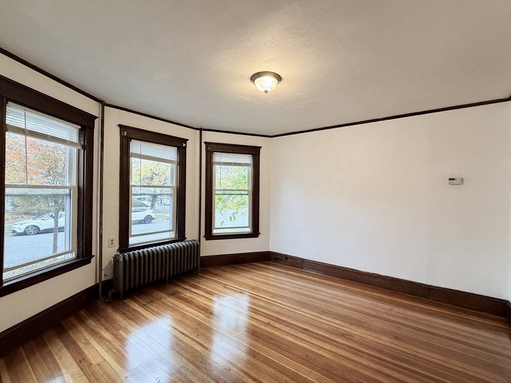 20 Clark Street, Unit 1 Framingham, MA 01702 - Photo 5 of 17 an empty room with wooden floor and windows