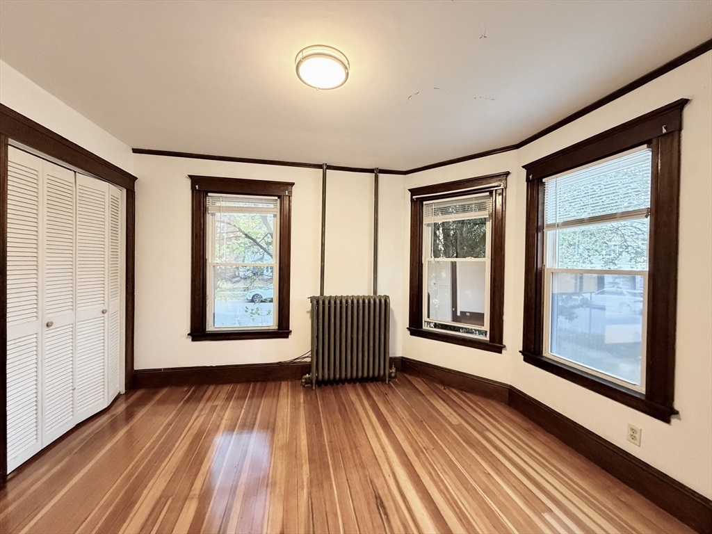 20 Clark Street, Unit 1 Framingham, MA 01702 - Photo 10 of 17 a view of an empty room with wooden floor and a window