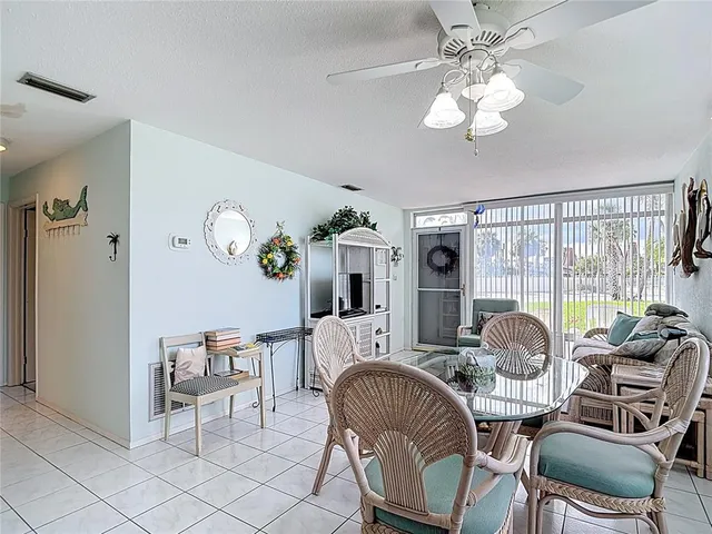 a living room with furniture a chandelier and a dining table