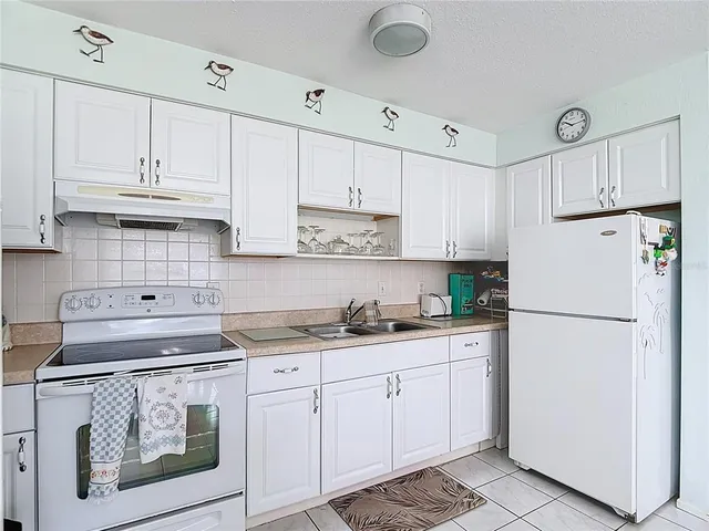 a kitchen with cabinets appliances a sink and a counter space