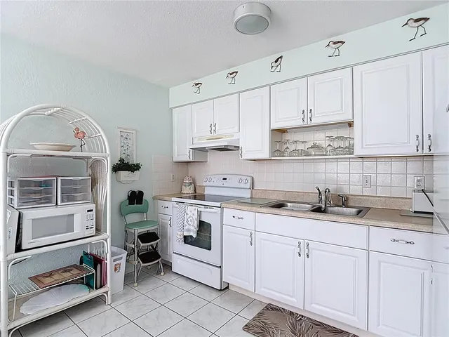 a kitchen with a sink dishwasher and white cabinets