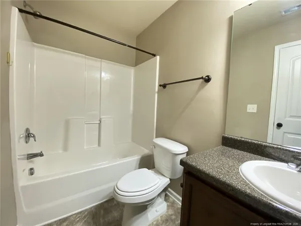 a bathroom with a granite countertop sink toilet mirror and shower