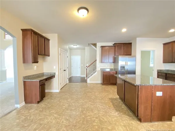 a large kitchen with kitchen island a sink stainless steel appliances and cabinets