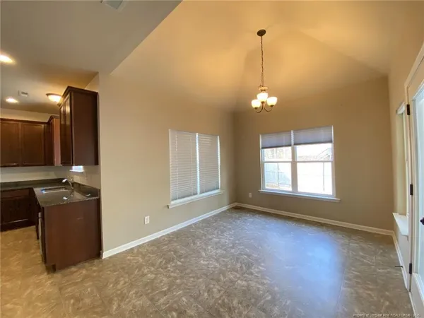 an empty room with windows and ceiling fan