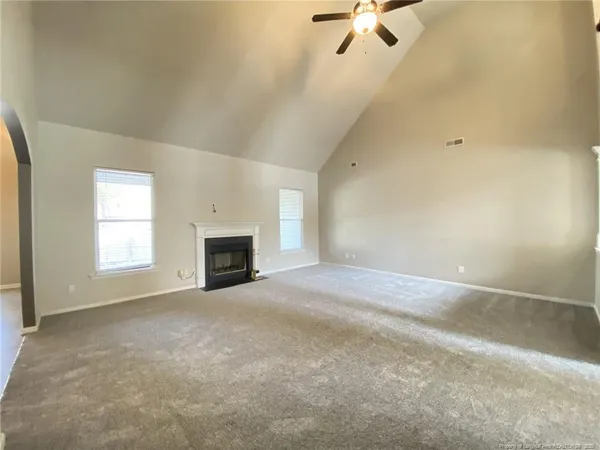 an empty room with windows and fireplace