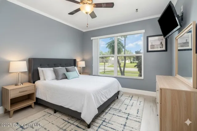 a bedroom with a large bed and a flat tv screen