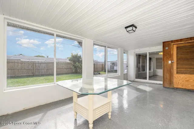 a view of a porch with furniture and floor to ceiling window
