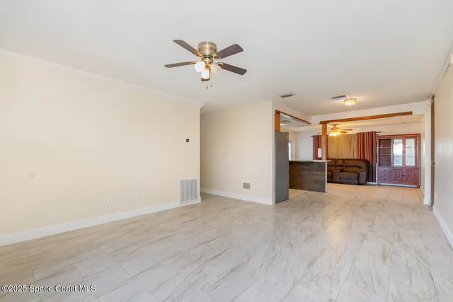 a view of empty room with wooden floor and window