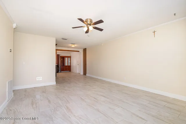 a view of a livingroom with a ceiling fan and window