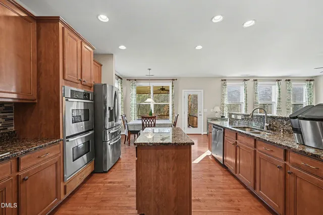 a kitchen with stainless steel appliances granite countertop a refrigerator stove and oven