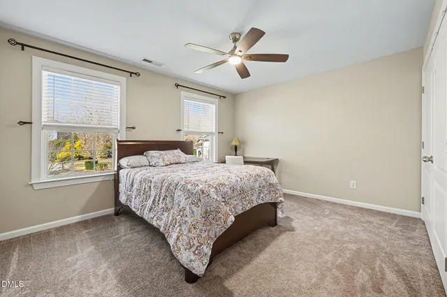 a bed sitting in a bedroom next to a window
