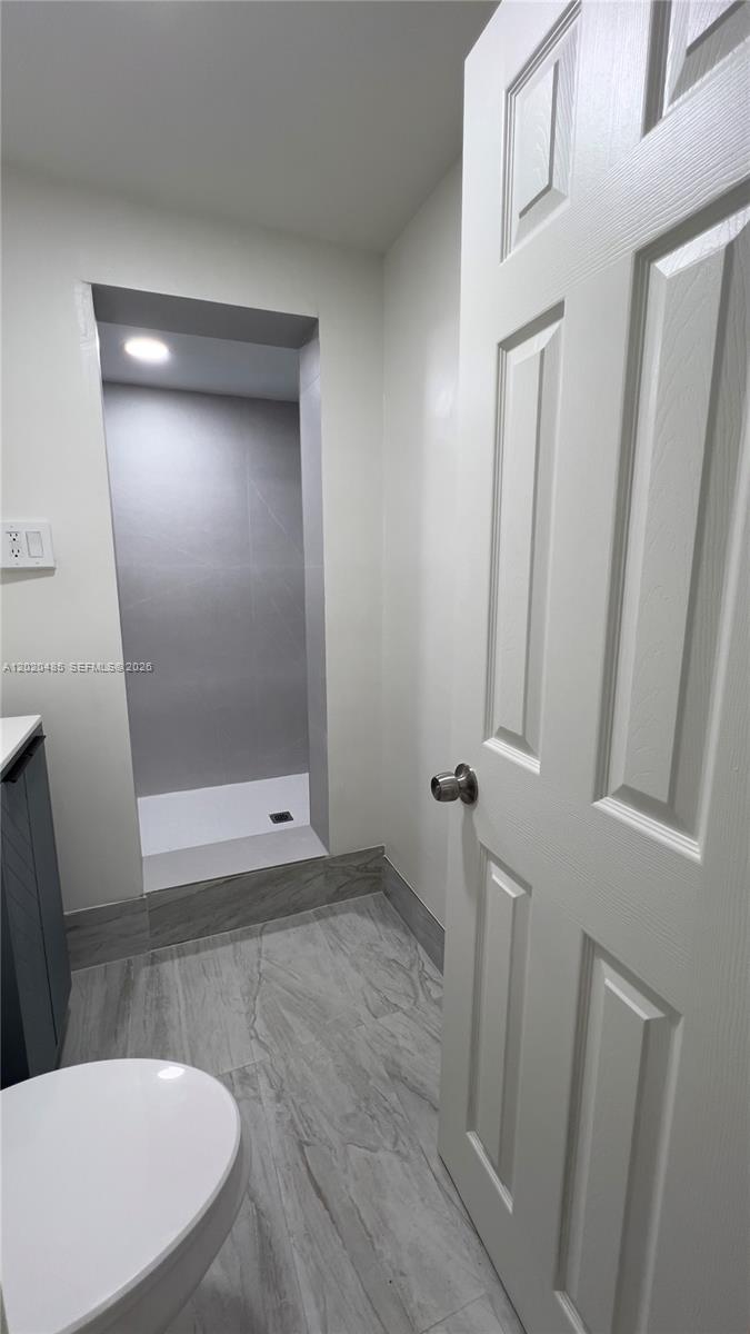 1845 Bay Road, Unit 1 Miami Beach, FL 33139 - Photo 6 of 9 a view of a hallway with a glass door and a mirror